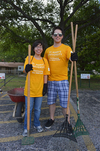 Two students stand proud after doing volunteer yard work.