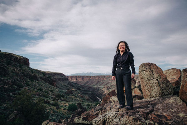 Dr. V in front of a scenic view of canyons in Taos