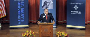 Speaker stands at a podium at a Forum on Entrepreneurship Breakfast