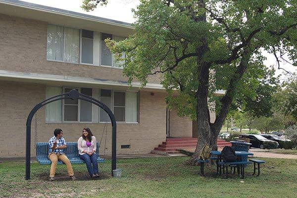 Marian Hall courtyard featuring a swing and shade trees