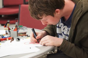 A student works on a drawing of a robot in the S.A. Best competition