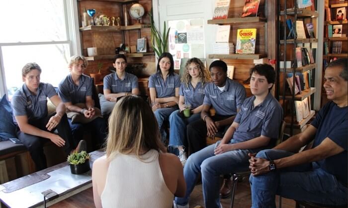 A group of people sitting on couches in a circle.