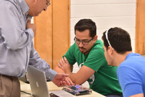 Djaffer Ibaroudene, Ph.D., helps students in class.