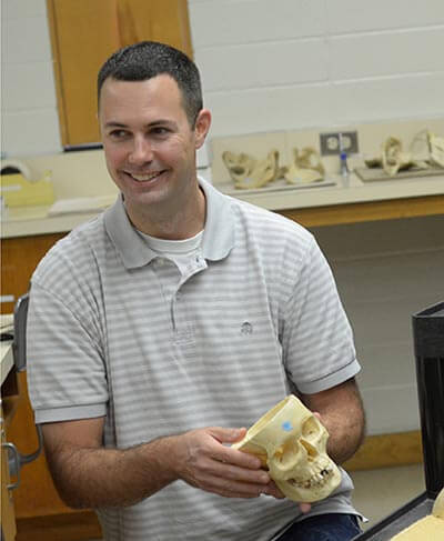 Ted Macrini holding a model of a skull