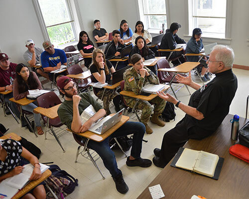 theology professor lecturing to class full of students