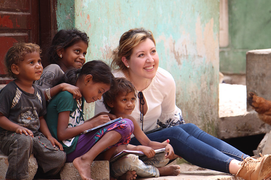 St. Mary's University student Gisell Orozco reads a book with a group of children on the streets of Bangalore's slums.