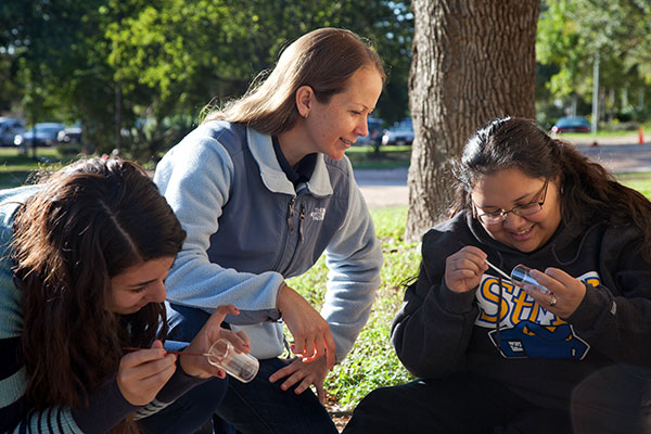 Melissa Karlin, Ph.D., instructs students during an on-campus lab in which they painted and tracked ants. 