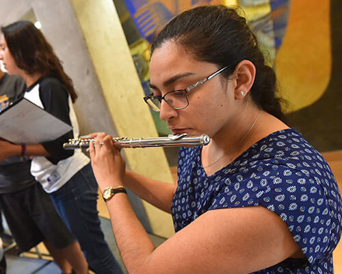 Female student plays the flute.