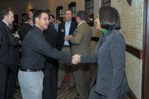 An E-Scholar greets and networks with guests at a Forum on Entrepreneurship Breakfast Series event.