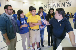 Richard Cardenas, Ph.D, far right, presents a physics experiment to local middle school students.