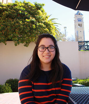 Iliana De La Cruz sits by the Cotrell Commons.