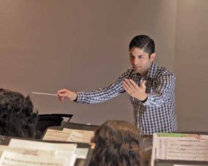 Image of director of bands conducting the St. Mary's Concert Band.