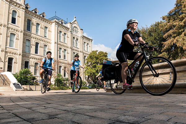 Stephanie Ward, Ph.D., and student volunteers riding their bicycles to deliver books as part of Ride for Reading. 