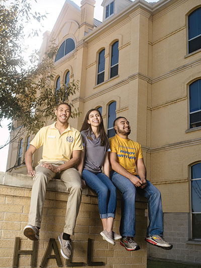 Students sit across from Founders Hall. 