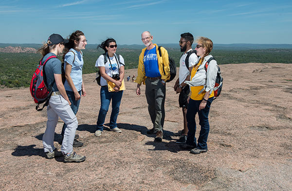 St. Mary's University Environmental Science professors and students standing on the summit of Enchanted Rock. 