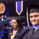A male student graduates in regalia