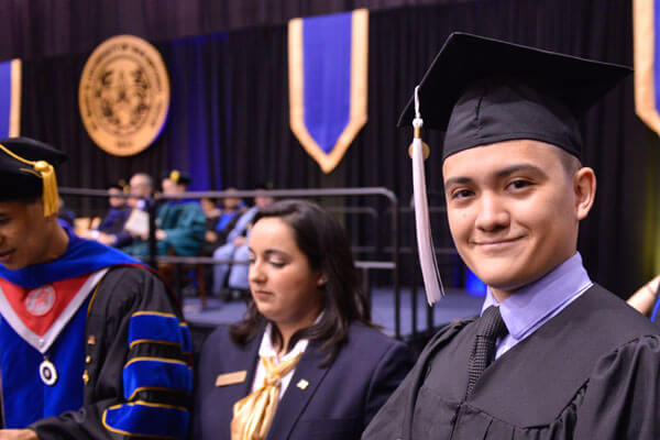 A male student graduates in regalia