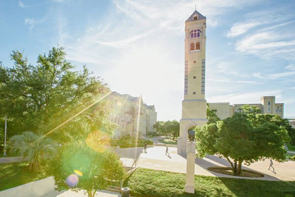 The Bell Tower stands prominently in the background while a bright summer sun flares in the foreground