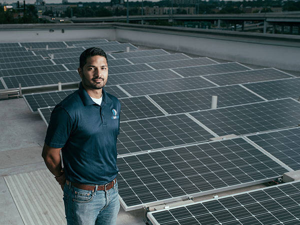 Supratim Srinivasan (B.S. '11) stands among solar panels.