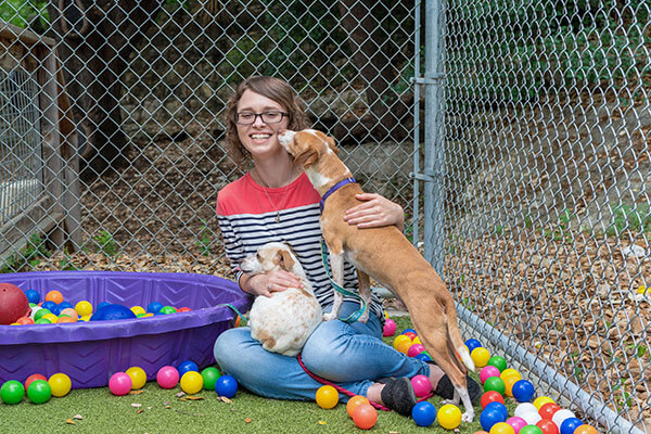 Management senior Kaitlyn Bloch sits with two dogs.