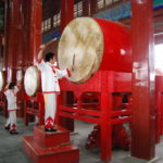 A person beats a big Chinese drum.