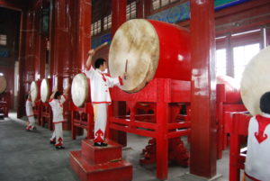 A person beats a big Chinese drum.