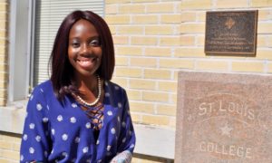 J.D. student Aisha Denis stands in front of St. Louis Hall.