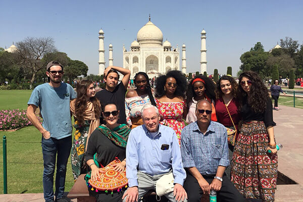 A group of students and faculty smile in front of the Taj Mahal