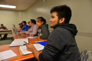 A student takes notes in a business class.