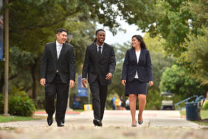 Three business school students walk across campus.