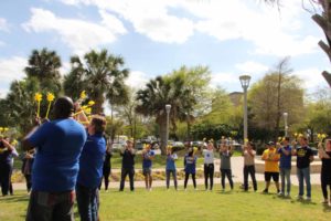 students hold yellow pinwheels