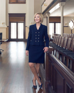 Justice Marion stands in the historic courtroom.