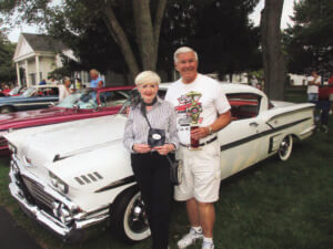 John and Peggy Sieffert stand with trophies at a car show.