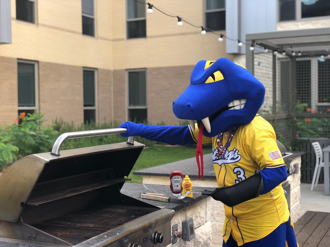 St. Mary's mascot, Rattler Man, grills burgers at Périgueux Hall.