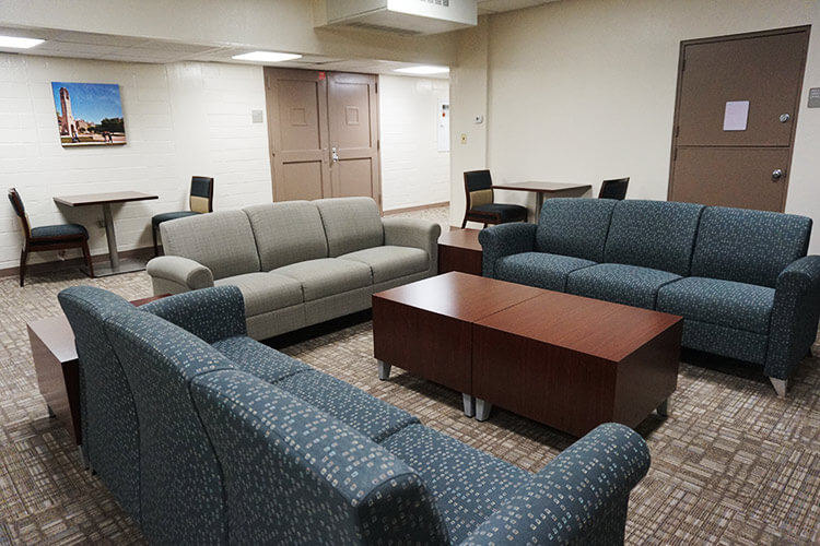 Three couches surrounding a coffee table in a Chaminade Hall lounge