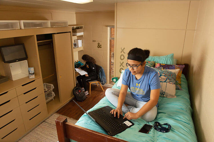 Two female students work on homework in a Dougherty Hall model room