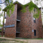 Leies Hall, a three-story brick building surrounded by trees
