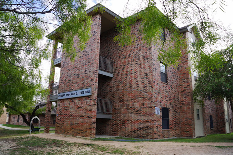 Leies Hall, a three-story brick building surrounded by trees