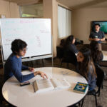 Students study around a common room table in Marian Hall