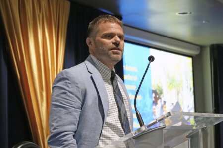 Jason King speaking at a podium.