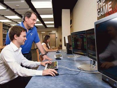 Richard Bauer with a student using a computer