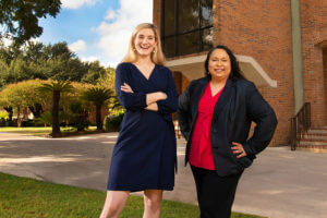 Marina Lewis and Katherine Cabello-Flores stand behind the Raba Building.