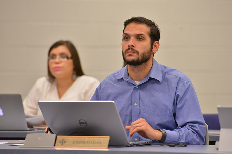 Joseph Mariña, founder of Tactical Agile and a St. Mary’s MBA alumnus, sits behind a computer in a business classroom.