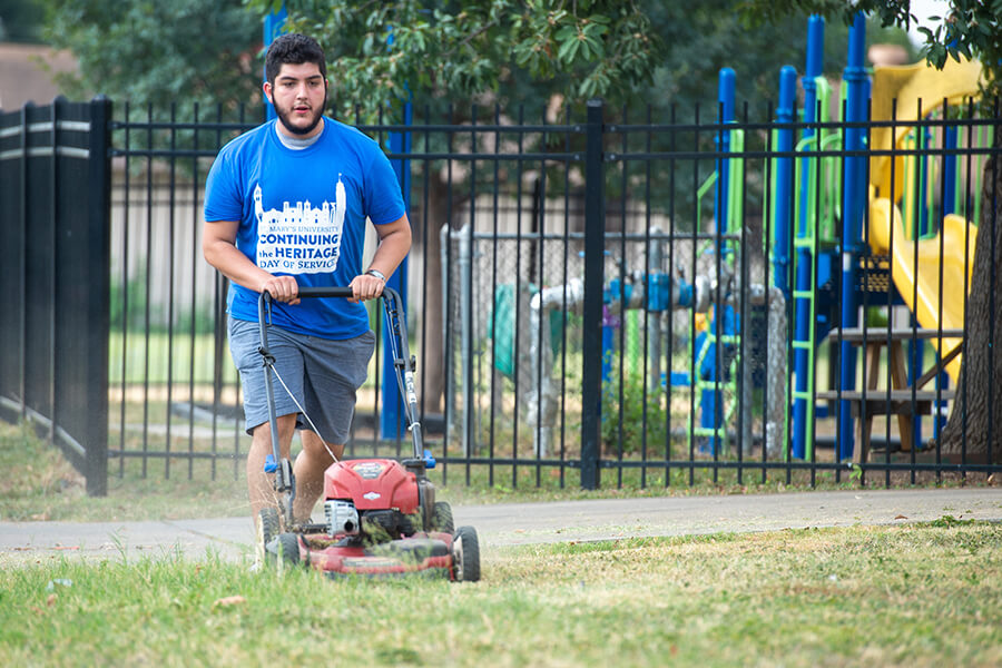 A student helps with yard work during Fall 2019 Continuing the Heritage.