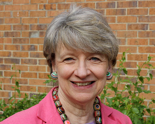 Bonnie Roberts stands in front of a brick wall.