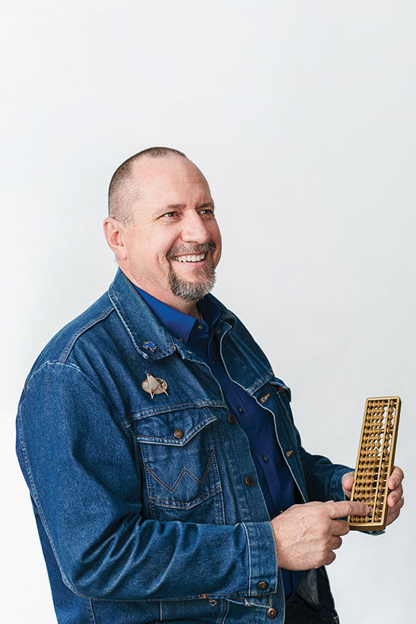 Math Professor Paul Uhlig plays with a golden abacus.