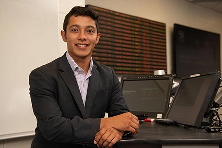 Rudy Martinez stands in the School of Business.