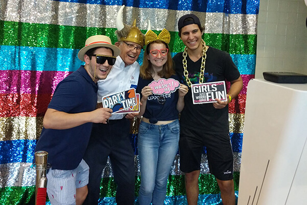 Students pose with a Marianist brother at a photo booth