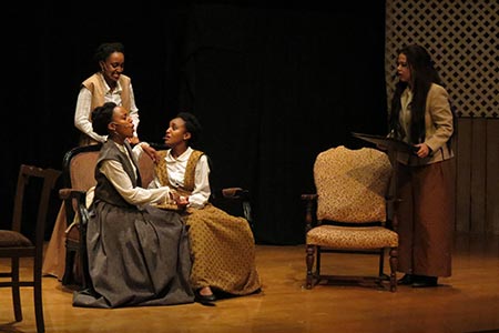 Four female actresses on stage during a production of Little Women