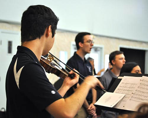 violin player rehearsing with choir